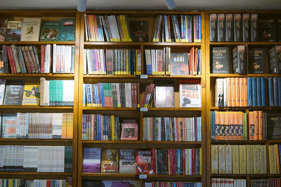 A well-organized library with rows of bookshelves filled with diverse literature.