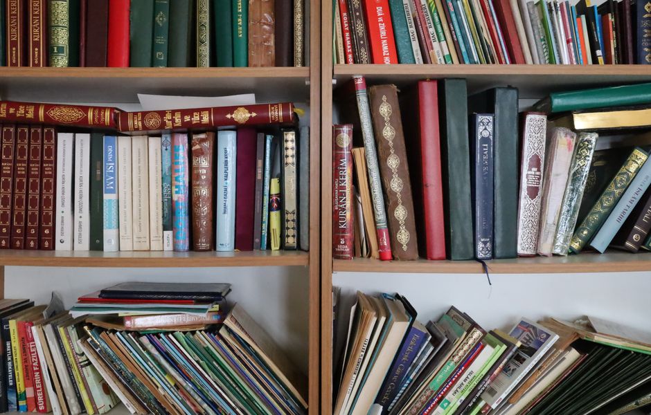 A close-up view of vintage encyclopedias on a library bookshelf, highlighting the ornate leather bindings.